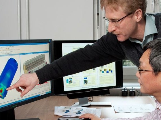 Dr. Holger V&ouml;lzke (stehend) und Dr. Linan Qiao begutachten die Simulation eines Beh&auml;lters f&uuml;r hochradioaktiven Abfall.